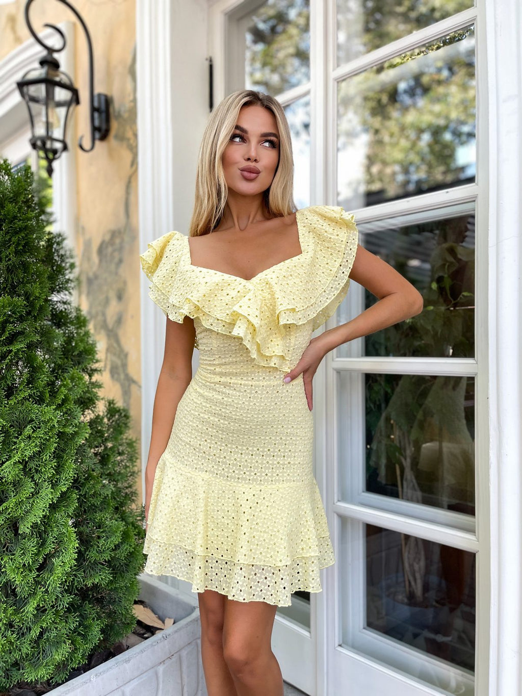 Waist detail of yellow broderie anglaise dress showing fitted silhouette and cotton eyelet fabric