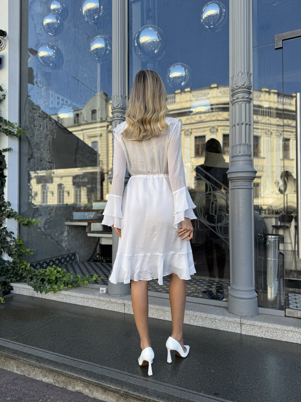 Back view of white ruffle midi dress with asymmetrical hem - cottagecore wedding dress